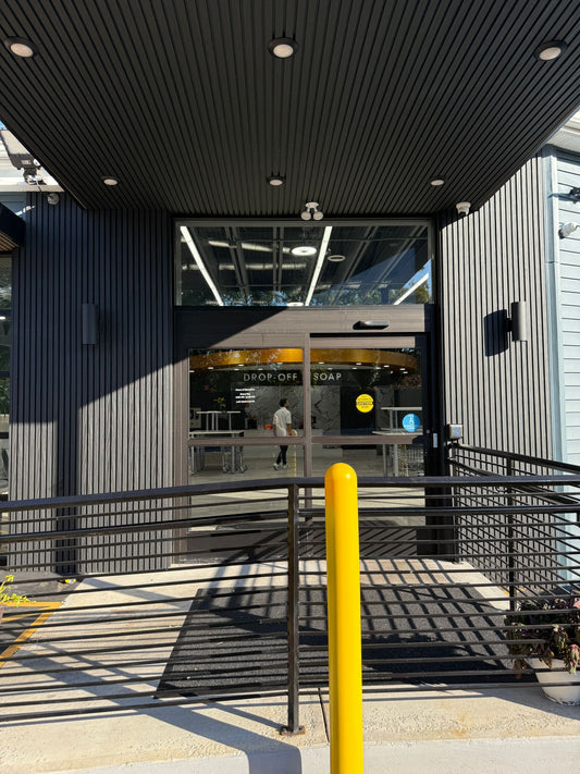 Laundry service entry door framed by black composite cladding
