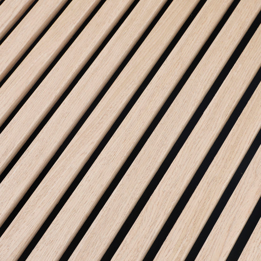 Close-up of light oak veneer grain and evenly spaced black gaps between acoustic wood slats