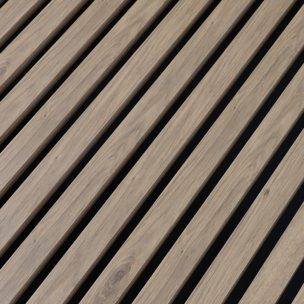 Close-up of the white wood veneer grain and evenly spaced black gaps between acoustic slats