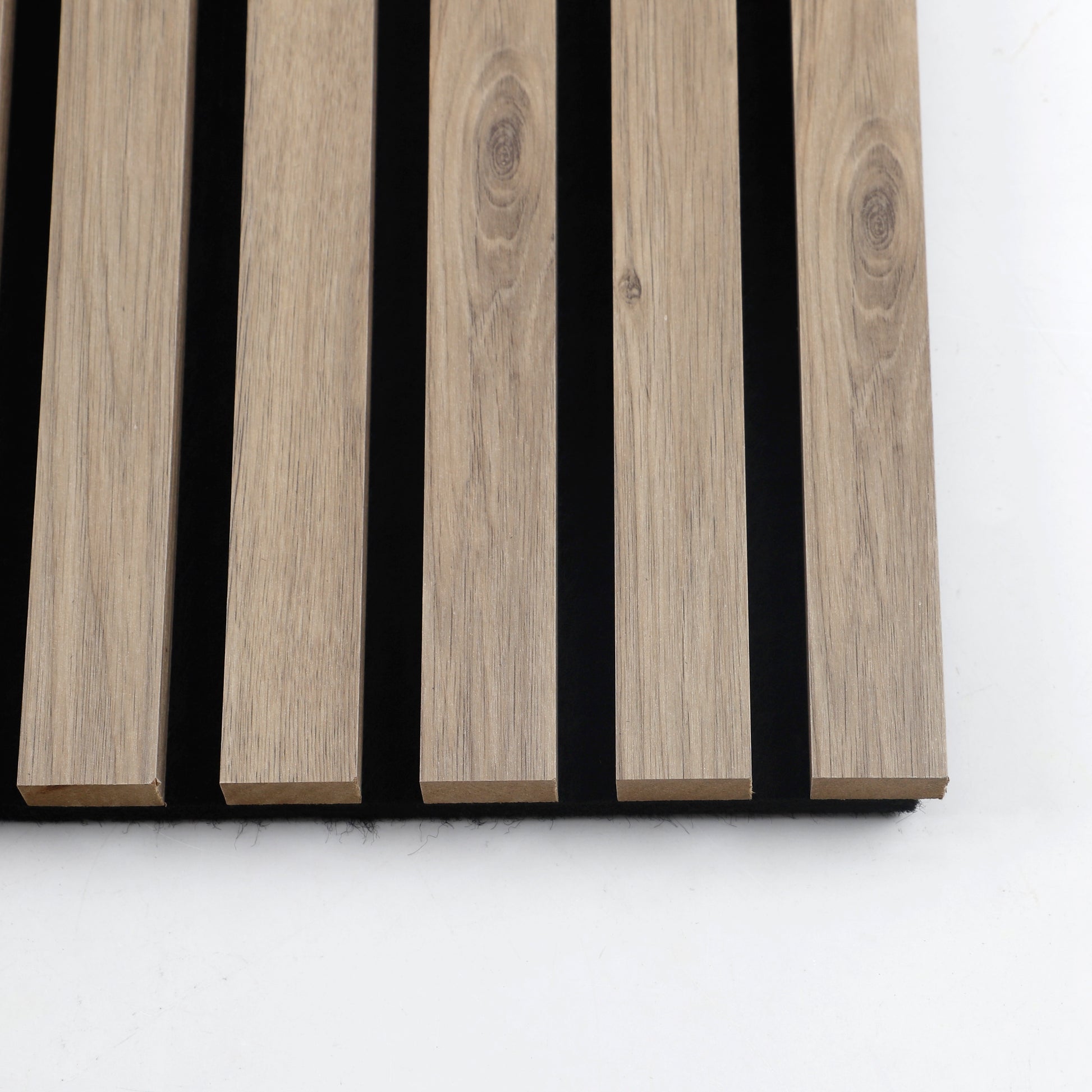 Close-up of five white wood veneer slats with natural grain and black acoustic backing