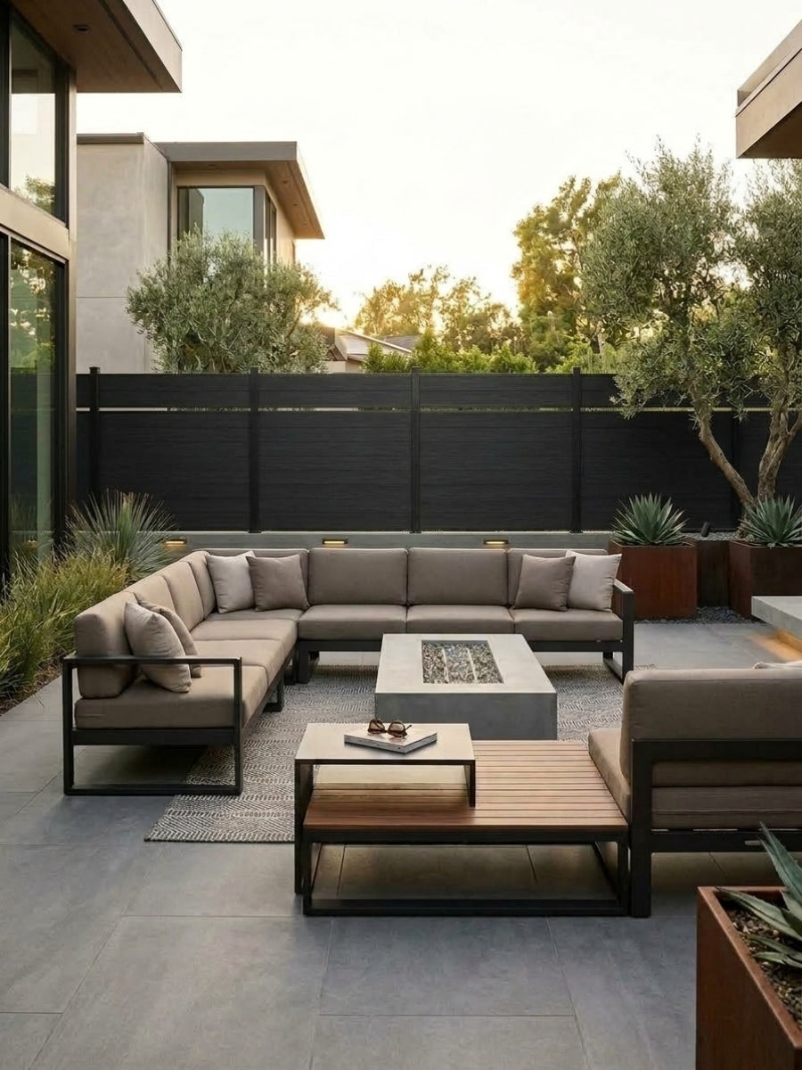 Black single divider composite fence installed behind a modern outdoor sectional seating area
