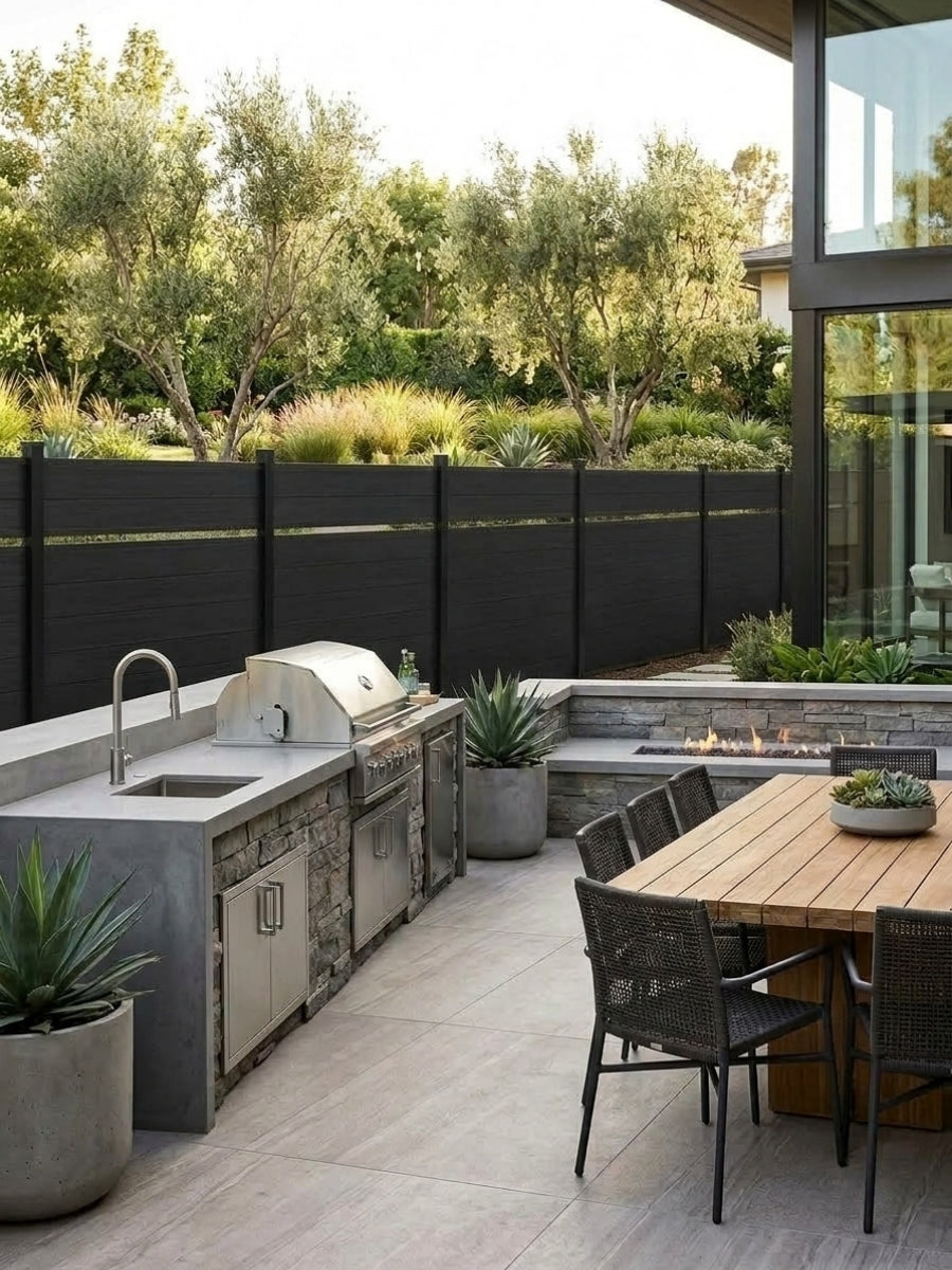 Black single divider composite fence surrounding a modern outdoor kitchen and dining patio