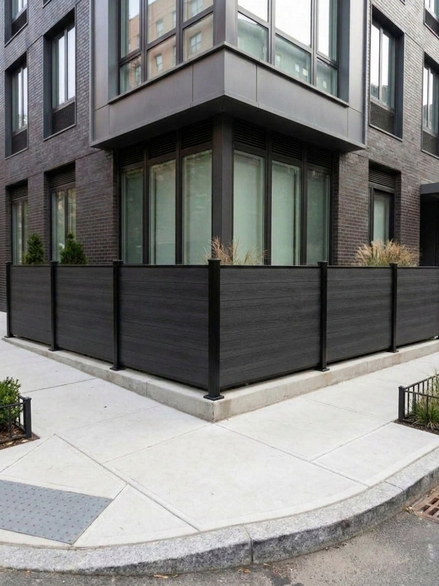 Black composite privacy fence panels installed around the corner of a modern urban residence