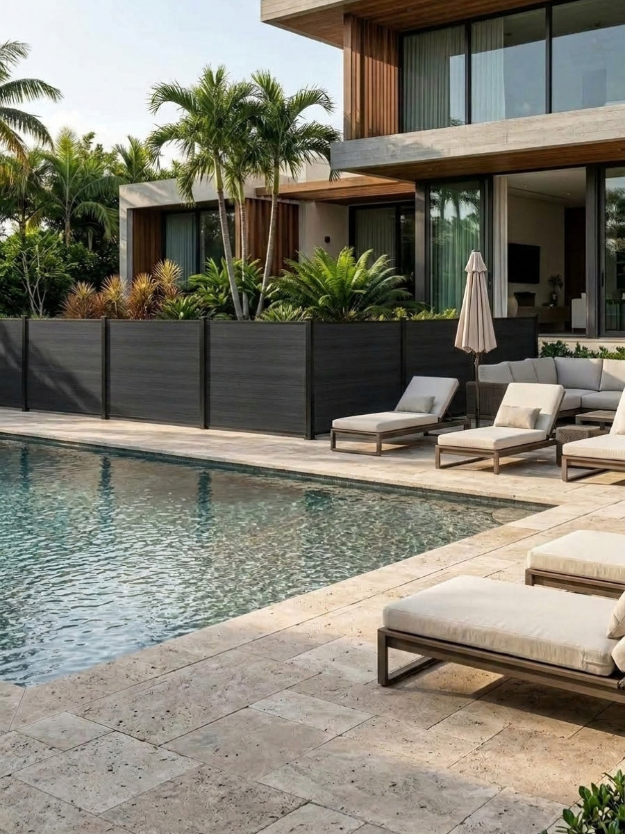 Black composite privacy fence panels installed beside a modern backyard swimming pool