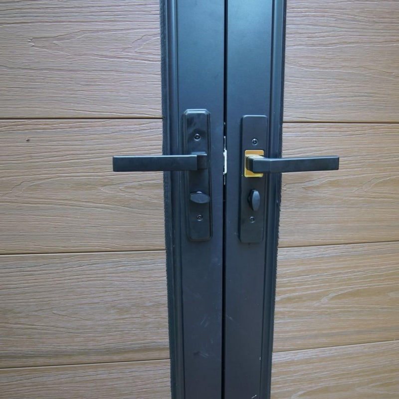 Black metal door with handles on a wooden panel background