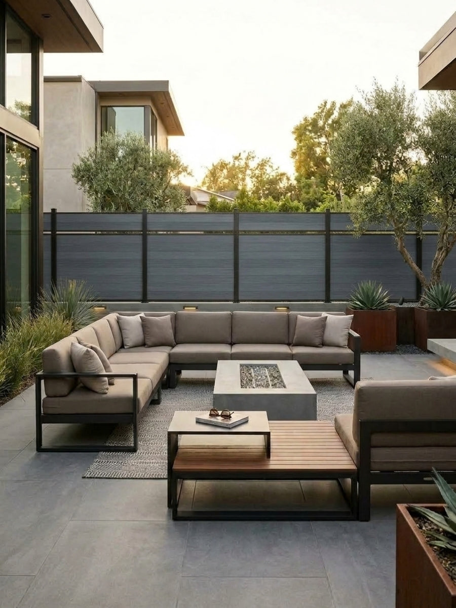 Modern outdoor lounge bordered by a light gray single divider composite fence and dark posts