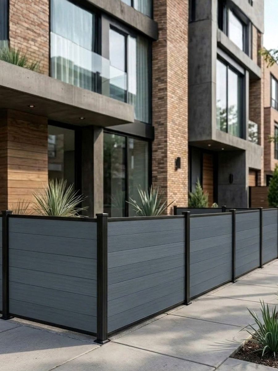 Light gray composite privacy fence panels enclosing a corner patio at a modern townhouse