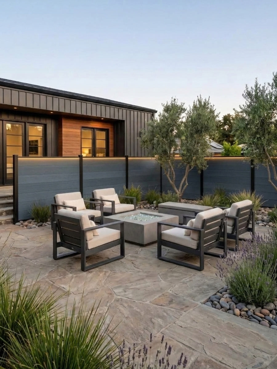 Light gray composite privacy fence installed behind an outdoor fire pit seating area