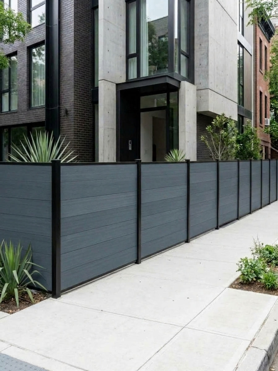 Light gray composite privacy fence installed along the sidewalk outside a modern residence