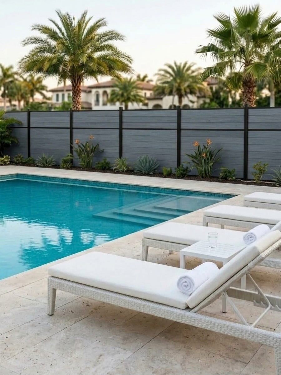 Light gray center-trim composite fencing installed beside a swimming pool and lounge chairs