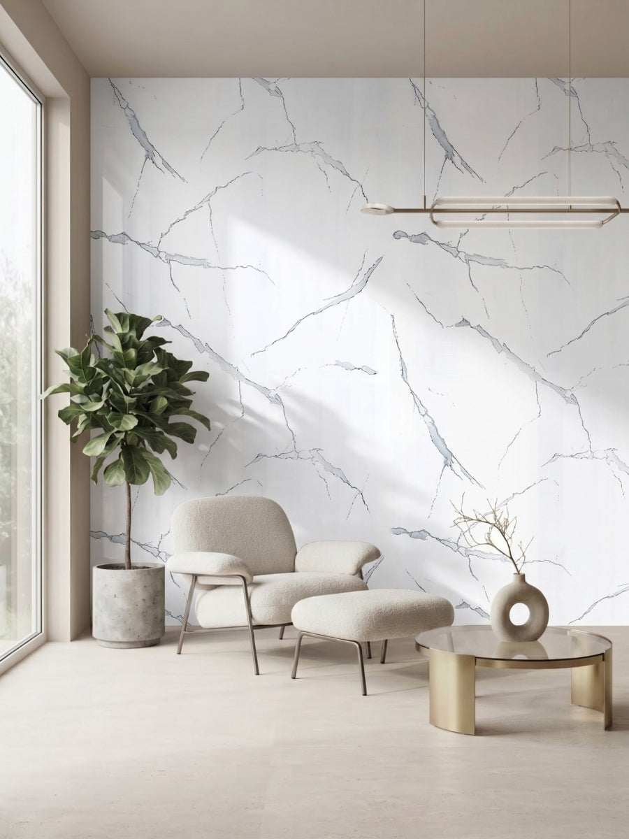 Minimalist sitting area with a White Gray Pearl Marble PVC feature wall, cream lounge chair, ottoman, and potted tree.